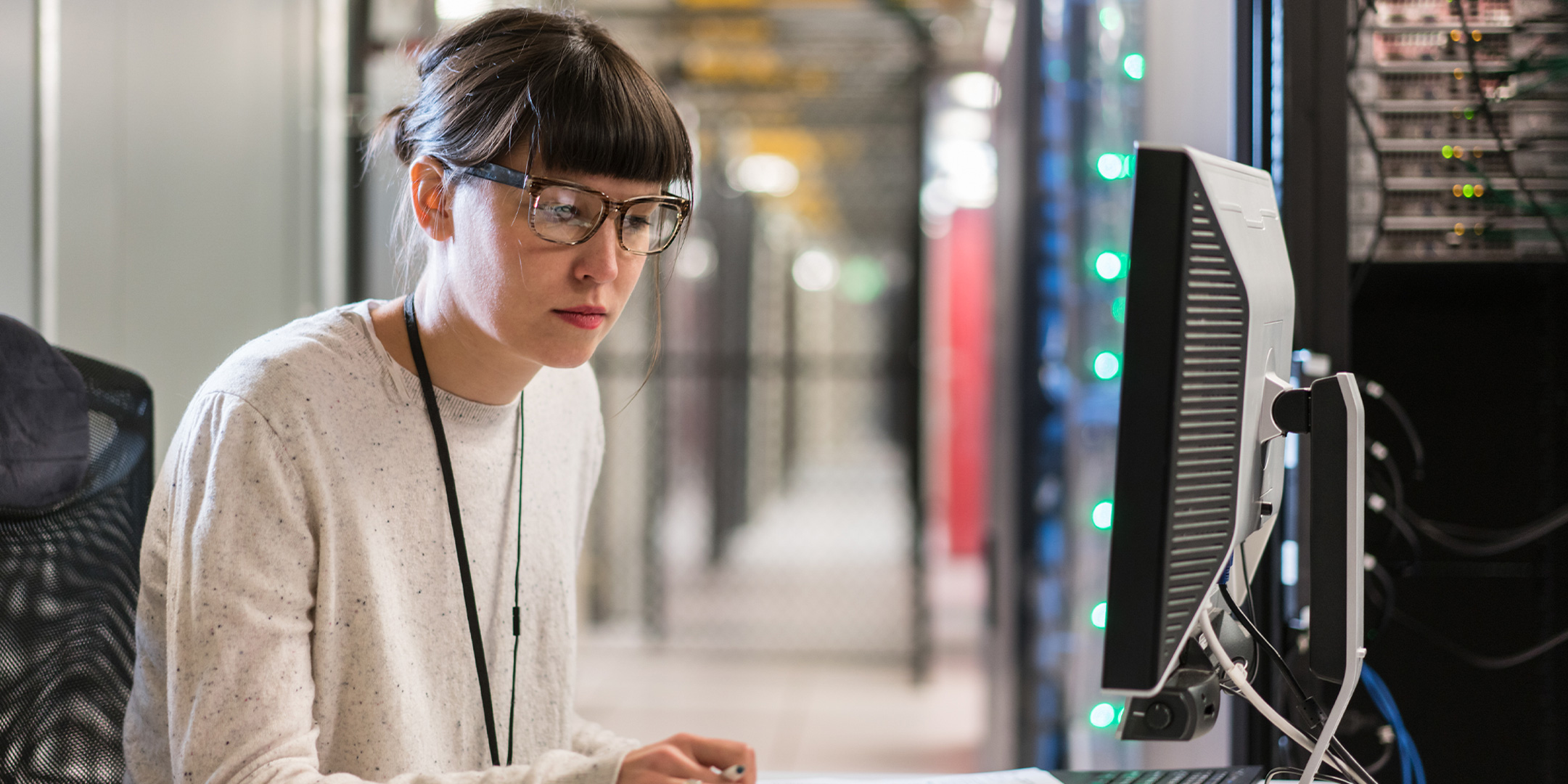 Woman writing in server room